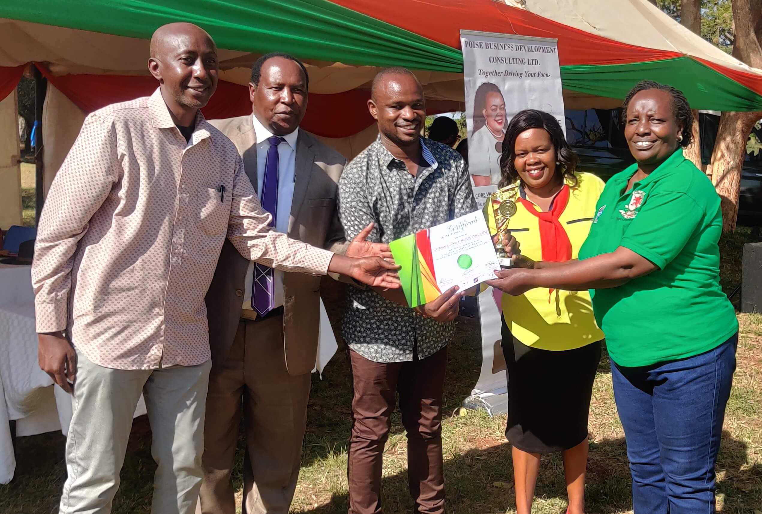 On the right Ms Mary Kandie receives a trophy from the KALRO and Kilimo Biashara Expo 2022 team upon winning the best stand Universities Category. 1